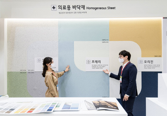 30일 서울 삼성동 코엑스에서 열린 '2021 K-HOSPITAL FAIR(국제병원의료산업박람회)' LX하우시스 전시부스에서 직원이 고객에게 의료시설용 전용 바닥재 제품에 대해 설명하고 있다. <LX하우시스 제공>